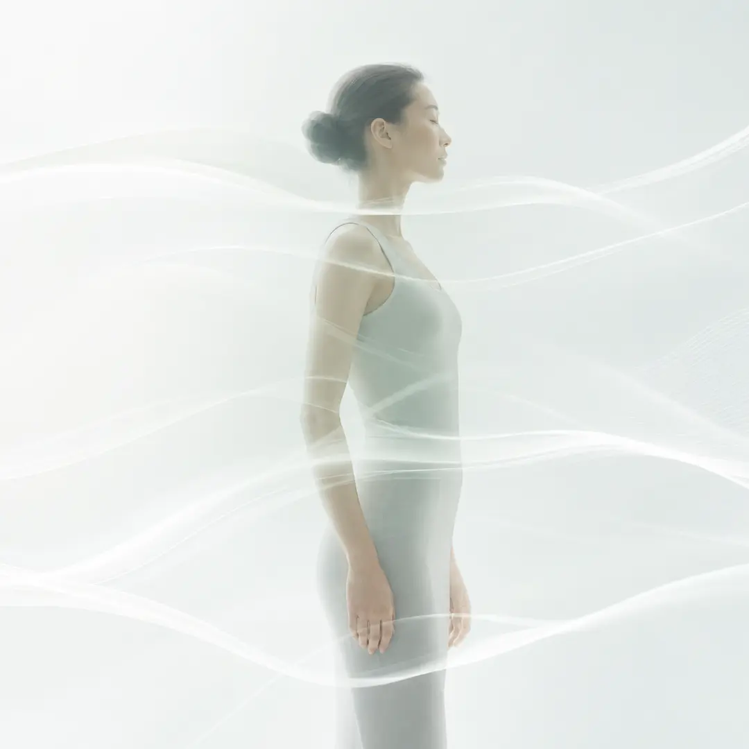 A serene woman surrounded by soft white energetic waves